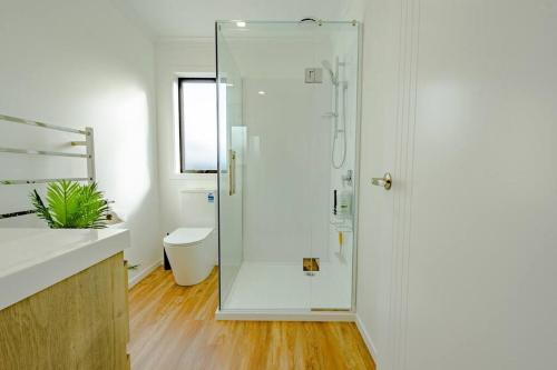a bathroom with a shower with a glass door at City Centre Elegance Apt 3 in Hamilton