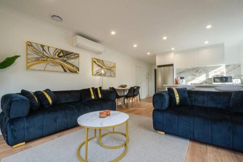 a living room with a blue couch and a table at City Centre Elegance Apt 3 in Hamilton
