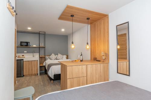 a bedroom with a bed and a desk with a kitchen at Barcelo Coliving in Medellín