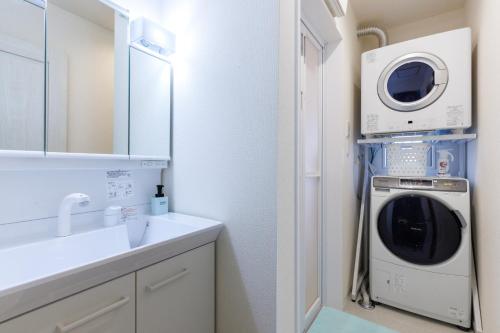 a bathroom with a washing machine and a sink at 恩納村にあるMAXIMAOceanTerraceは1棟貸BBQ利用可能 in Onna