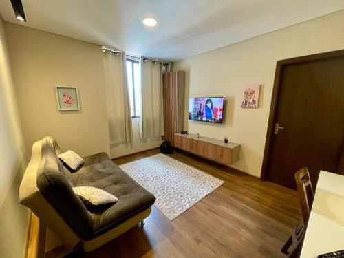 a living room with a couch and a flat screen tv at Moderno garzonier in Cochabamba