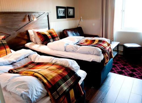 a room with three beds with blankets on them at Sälens Högfjällshotell in  Högfjället