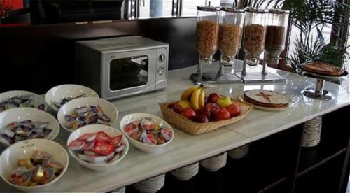 a table with bowls of food and a microwave at Holiday Inn Express Molins de Rei by IHG in Molins de Rei