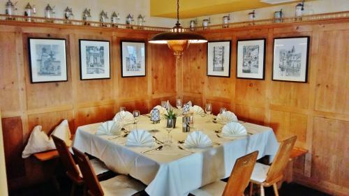 a dining room with a table with white tablecloths at Gasthof zur Strass in Eugendorf