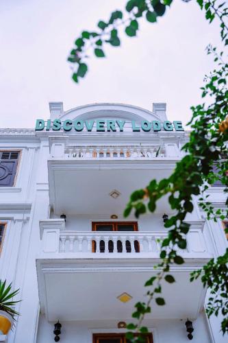 a white building with a sign on top of it at Discovery Lodge Phong Nha in Cừ Lạc