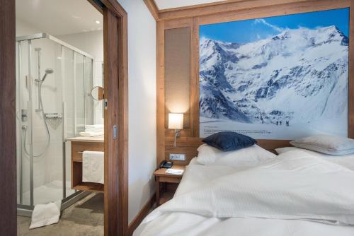 a bedroom with two beds and a mountain mural at Hotel Eden Rock in Bad Gastein