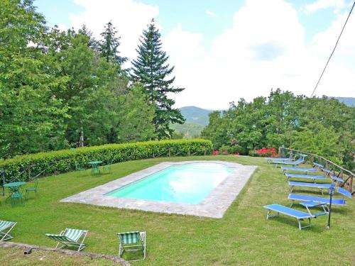 a group of chairs sitting around a swimming pool at Belvilla by OYO Villa Roseto in Poggioni