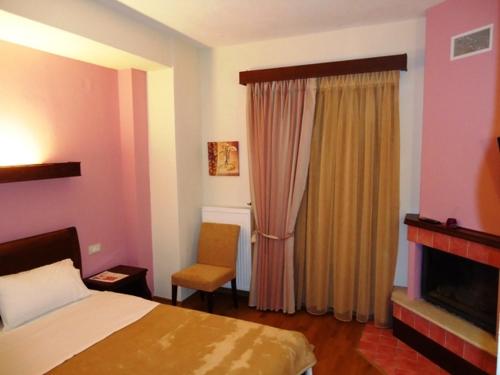a hotel room with a bed and a chair at Hotel Kokkinos Vrachos in Elati Trikalon