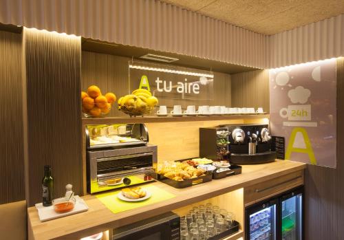 a restaurant with a buffet of food on a counter at Hotel A Pamplona in Pamplona