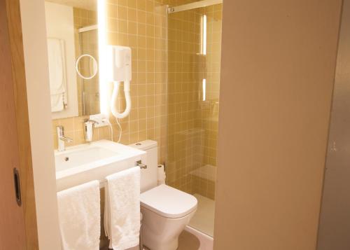 a bathroom with a toilet and a sink at Hotel A Pamplona in Pamplona