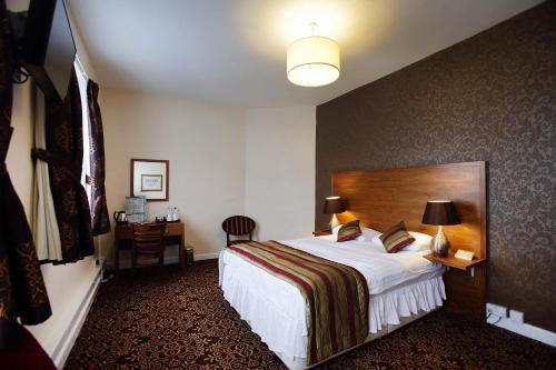 Habitación de hotel con cama y escritorio en The Three Tuns Hotel Wetherspoon, en Thirsk