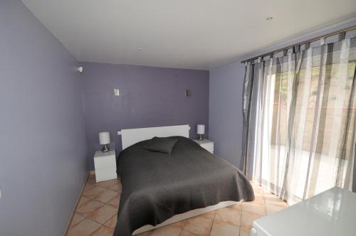 ein Schlafzimmer mit einem Bett mit einer schwarzen Decke in der Unterkunft Les Lauriers Blancs in Callas