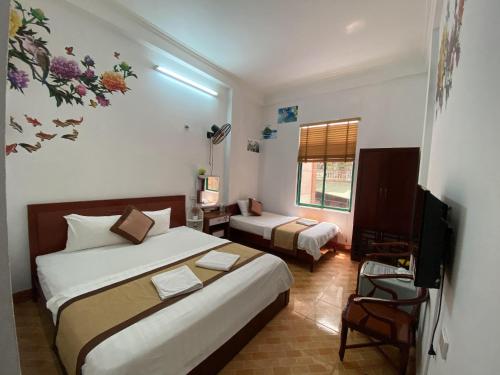 a hotel room with two beds and a television at Alex Ha Long Hotel in Ha Long