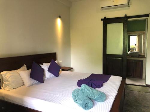 a bedroom with a bed with towels on it at Sithagi Villa Unawatuna in Unawatuna