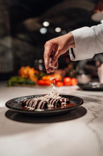 a chef is sprinkling sauce on a chocolate cake at Antiguo Molino de San Jerónimo in Mexico City