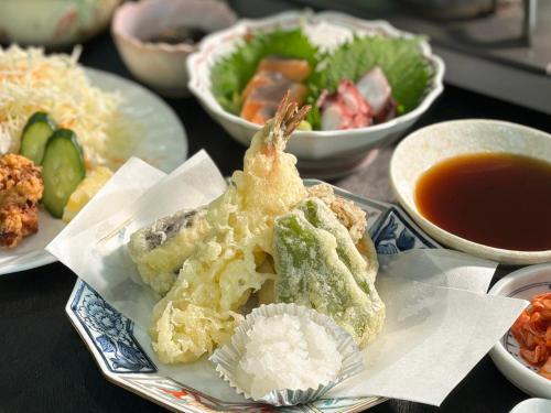 a table with plates of food and bowls of soup at Minami Hakone Villa in Kannami