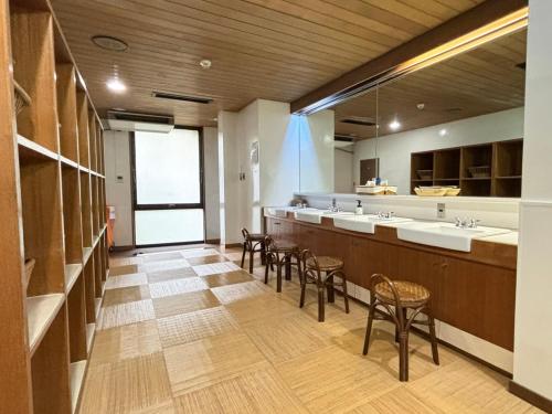 a large bathroom with two sinks and stools at Minami Hakone Villa in Kannami