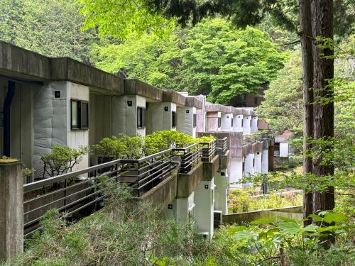 a row of buildings in a forest with trees at Minami Hakone Villa in Kannami