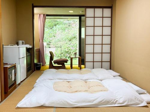 a large white bed in a room with a window at Minami Hakone Villa in Kannami