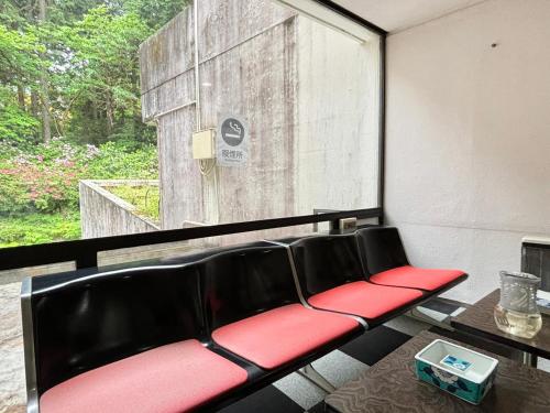 a red and black bench in a room with a window at Minami Hakone Villa in Kannami