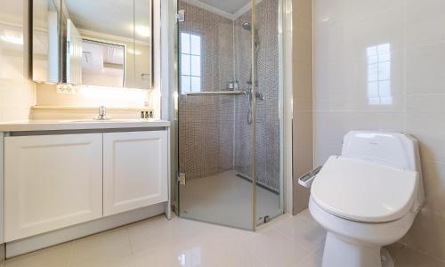 a white bathroom with a toilet and a shower at Kylin Villa resort Jeju in Seogwipo