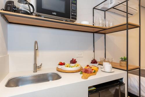 a kitchen counter with a sink and a microwave at Barcelo Coliving in Medellín