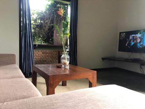 a living room with a coffee table with a vase on it at Sithagi Villa Unawatuna in Unawatuna
