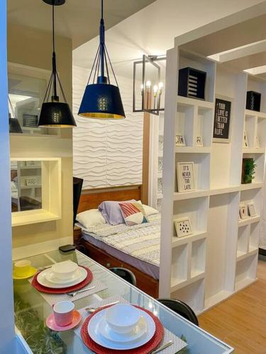una habitación con una mesa con platos y una cama en Deryll's Fun house, en Manila