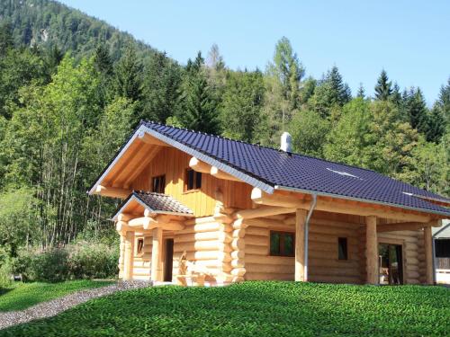 eine Blockhütte mit einem Sonnendach darauf in der Unterkunft Unique Holiday Home in Ruhpolding Germany With Sauna in Ruhpolding