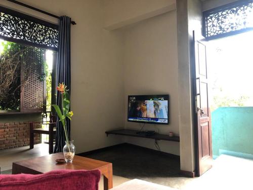 a living room with a tv and a table at Sithagi Villa Unawatuna in Unawatuna