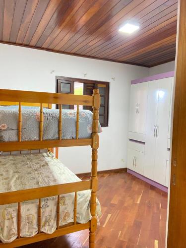 a bedroom with two bunk beds and a kitchen at Casa com vista deslumbrante in Campos do Jordão
