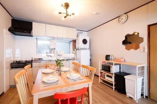 a kitchen with a table and chairs in a kitchen at oyadoya nagoya nakamura 地下鉄中村公園駅徒歩7分 最大8名 駐車場有り in Nagoya