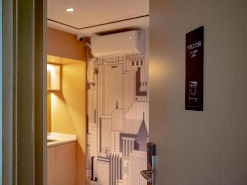 a bathroom door with a drawing of a city on it at City Comfort Inn Qianjiang Government in Qianjiang