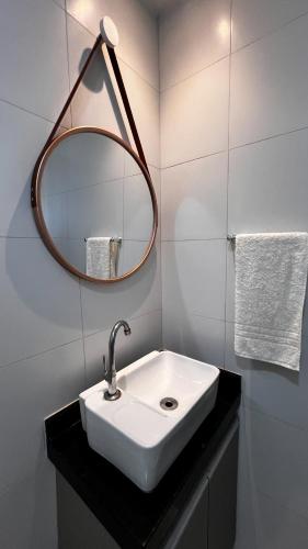 a bathroom with a white sink and a mirror at Pousada recanto porto tropical in Sirinhaém