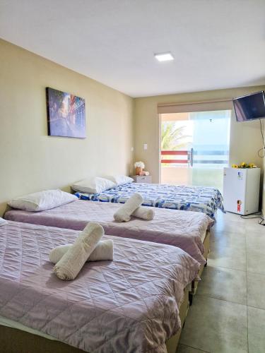 three beds are lined up in a room at Pousada recanto porto tropical in Sirinhaém