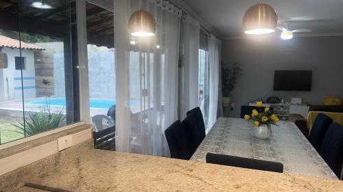 een eetkamer met een tafel en uitzicht op een zwembad bij Casa com piscina in Búzios
