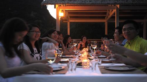 a group of people sitting around a table with wine glasses at Zen Box House in Yangshuo