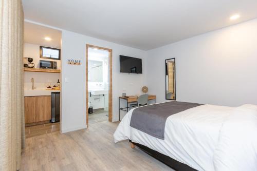 a bedroom with a bed and a kitchen with a desk at Barcelo Coliving in Medellín