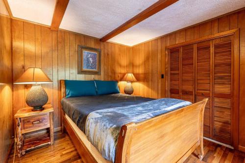 Un dormitorio con una cama en una habitación con paredes de madera. en Big Bear Cave, en Blue Ridge