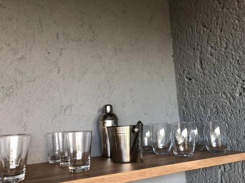 a shelf with glasses and a bottle on it at Recanto dos Coqueirais in São Miguel dos Milagres