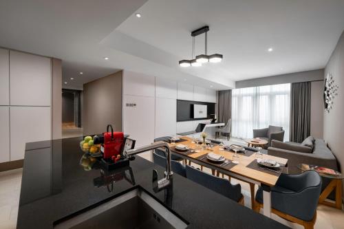 a kitchen and living room with a table and chairs at Fraser Place Puteri Harbour in Nusajaya