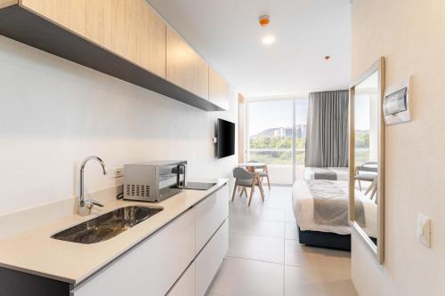 - une cuisine avec évier et un lit dans une chambre dans l'établissement Increible Apartasuit a solo 3 min de la playa, à Santa Marta