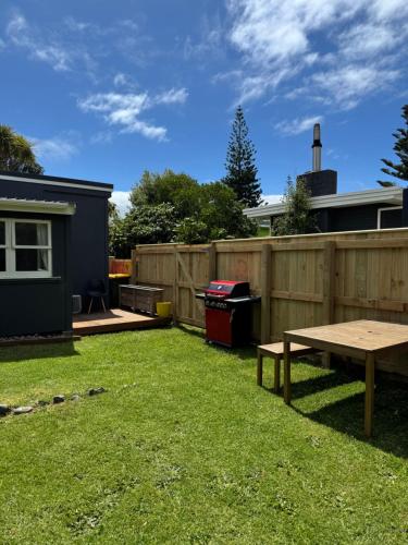 a backyard with a picnic table and a fence at Otaki Beach Guesthouse in Otaki Beach