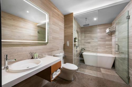 a bathroom with a sink and a tub and a toilet at Fraser Place Puteri Harbour in Nusajaya