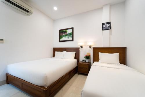 Postel nebo postele na pokoji v ubytování Saigon Park Hotel Dist 1