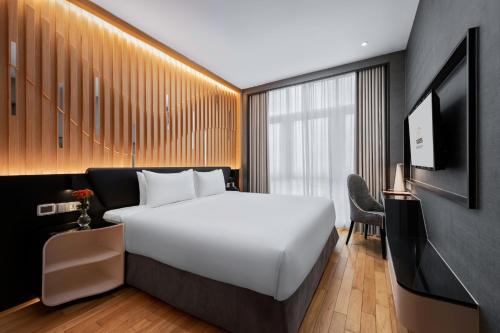 a bedroom with a large white bed and a television at Fraser Place Puteri Harbour in Nusajaya