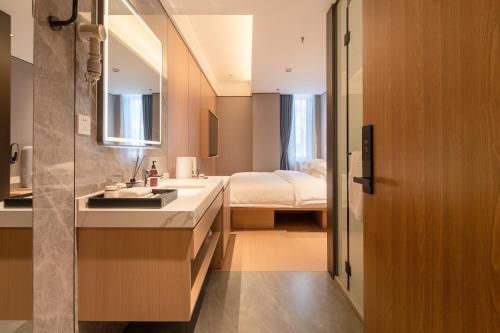 a bathroom with a sink and a bedroom at Dayin Youth Hostel - Old Town & People's Square& Rail Hub -Social Area -Bar -Café -Gym -Free Laundry Luggage Storage -24H Front Desk -English Service in Shanghai