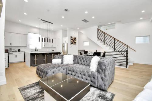 a living room with a couch and a kitchen at BlissHaven Luxe & Spacious in Downtown Houston with Soaking Tub ,Rooftop and free Parking in Houston