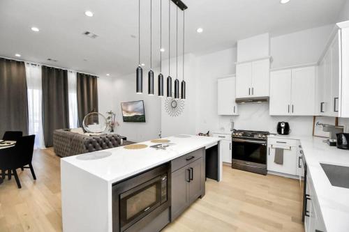 a kitchen with white cabinets and a table and a couch at BlissHaven Luxe & Spacious in Downtown Houston with Soaking Tub ,Rooftop and free Parking in Houston
