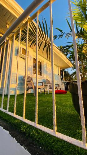 a house with a fence in front of a yard at The Beach House at Elyu Exclusive Beach Front Villa in Bauang